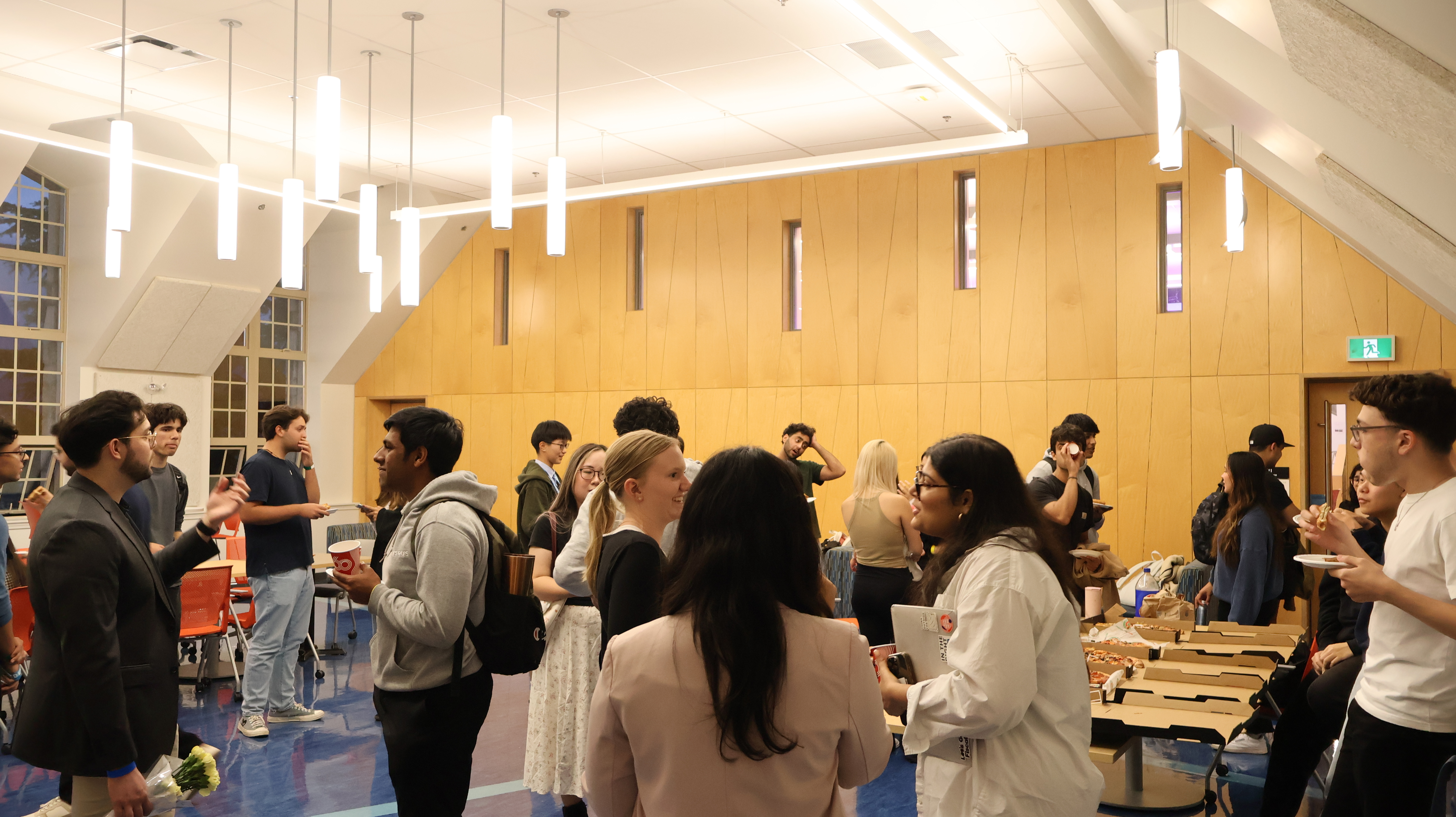 Students talking in small groups at a society networking night