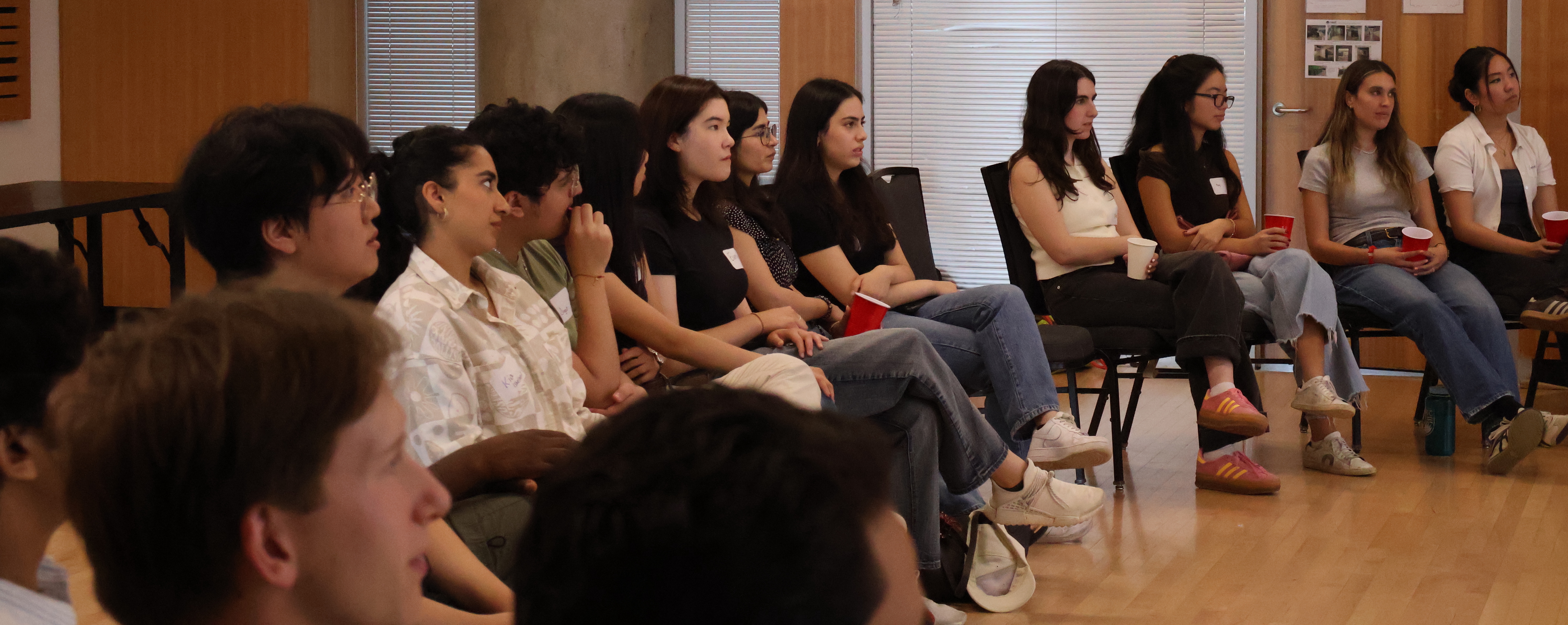 Students seated in rows, listening at a society event