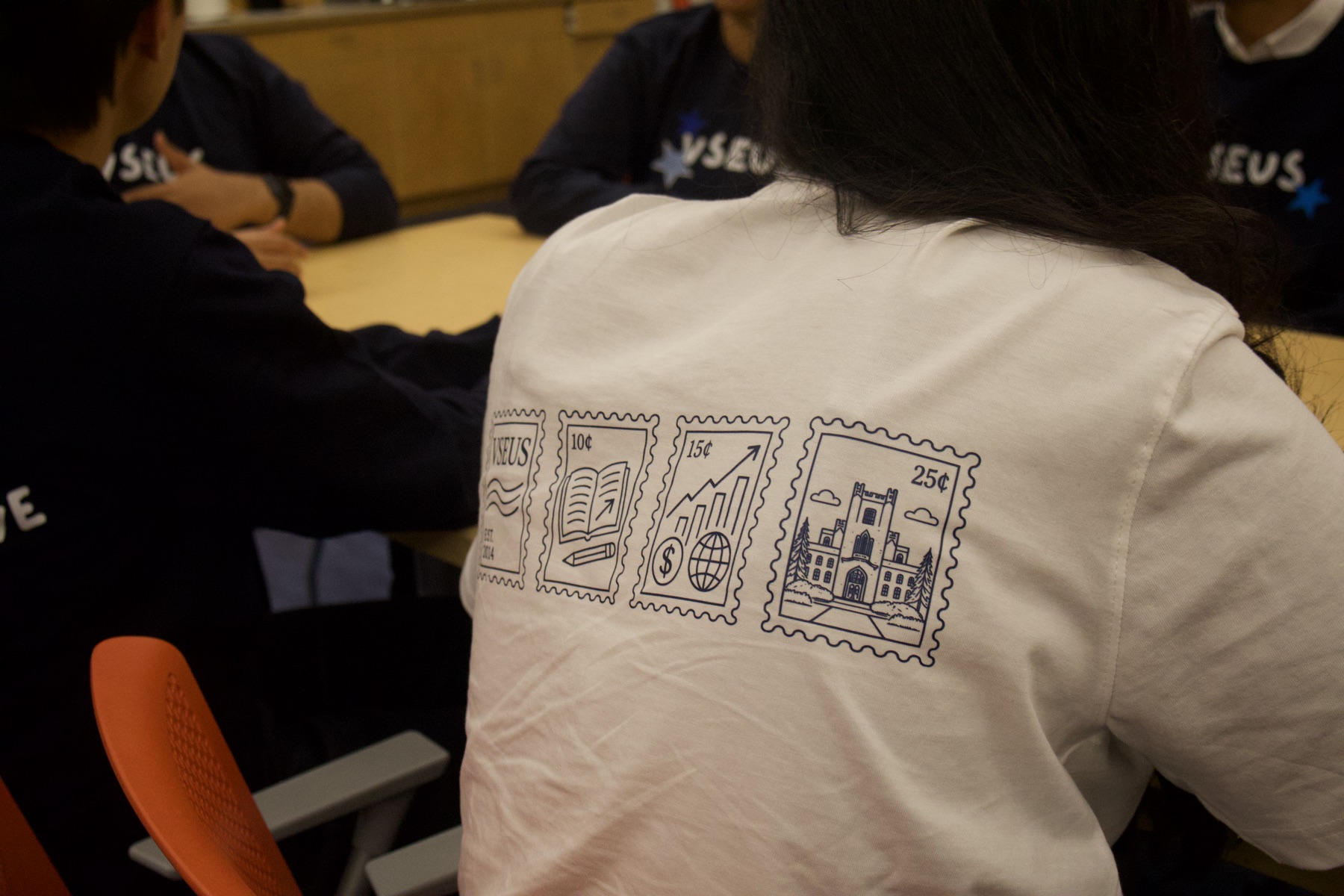Close-up of the stamp illustrations on the back of a white VSEUS tee